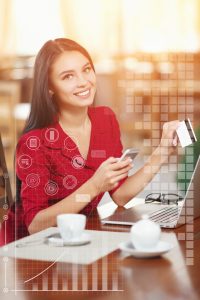 Young business woman holding mobile phone and credit card. Woman pays for a purchase with credit card and looking in camera. Purchase and shopping online. Business infographic